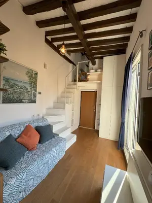 a living room with a blue couch and stairs at Pantheon Gabbianina Home in Rome