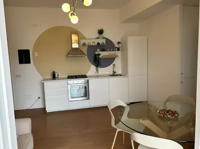 a small kitchen with a glass table and a stove at Momenti di felicità a Roma in Rome