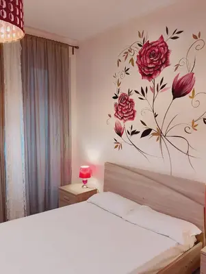 a bedroom with a bed with a flower mural on the wall at San Giovanni Rooms Roma in Rome