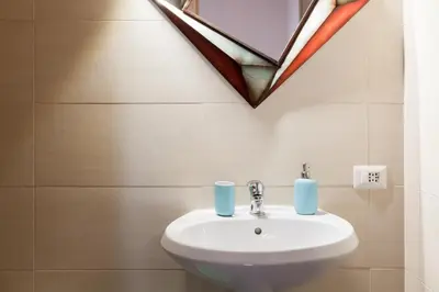 a bathroom with a sink and two blue candles at San Giovanni Rooms Roma in Rome