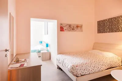 a small bedroom with a bed and a desk at San Giovanni Rooms Roma in Rome