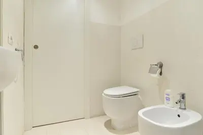 a white bathroom with a toilet and a sink at Rome City Center loft - special offer in Rome