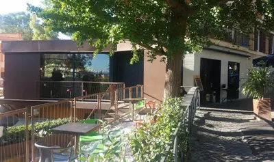 a patio with a table and chairs under a tree at Casa dei Vicoli, Classic Roman apartment in Rome