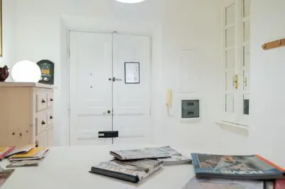 a white kitchen with books on a white counter at Casa dei Vicoli, Classic Roman apartment in Rome