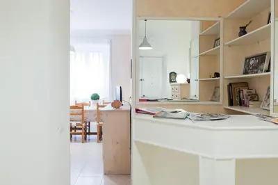 a white kitchen with a counter and a mirror at Casa dei Vicoli, Classic Roman apartment in Rome