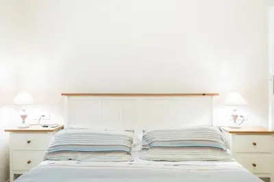 a white bed with two night stands and two lamps at Casa dei Vicoli, Classic Roman apartment in Rome