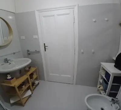 a white bathroom with a sink and a mirror at Casa dei Vicoli, Classic Roman apartment in Rome