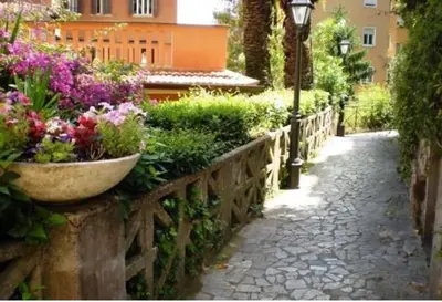 a garden with flowers and a stone fence at Casa dei Vicoli, Classic Roman apartment in Rome