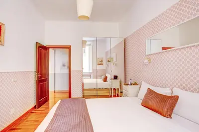 a bedroom with a white bed and a bathroom at Colosseo Families and Groups 2BDR Home and More in Rome