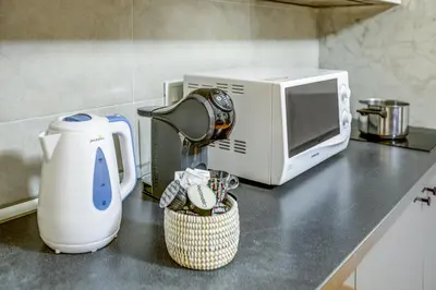 a kitchen counter with a coffee maker and a microwave at Colosseo Families and Groups 2BDR Home and More in Rome