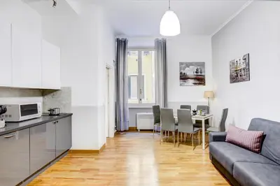 a kitchen and a living room with a couch and a table at Colosseo Families and Groups 2BDR Home and More in Rome