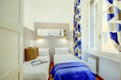 a small room with two beds and a window at Colosseo Families and Groups 2BDR Home and More in Rome