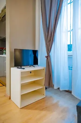 a tv on a cabinet in a room with a window at Palestro Apartments in Rome