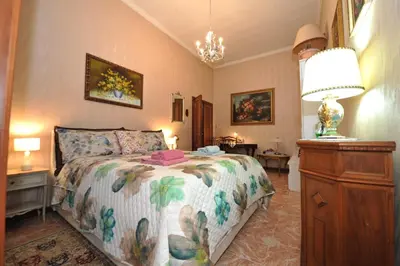 a bedroom with a bed and a lamp and a dresser at Casa Bianca in Rome