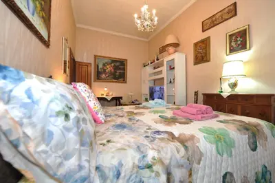 a bedroom with a large bed with a flowered blanket at Casa Bianca in Rome