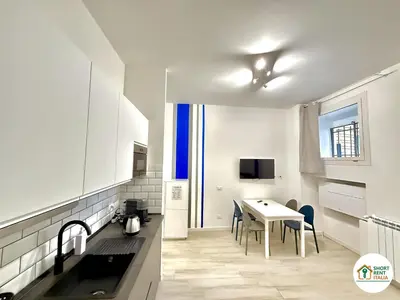 a kitchen with a sink and a table with chairs at Re di Roma - Colosseo House in Rome