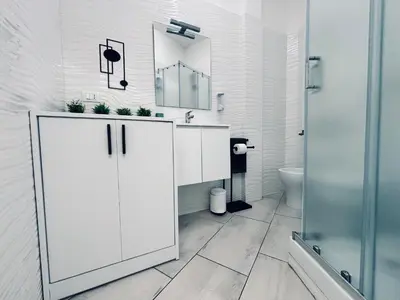 a white bathroom with a sink and a mirror at Roma Elena in Rome
