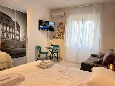a bedroom with a bed and a table and a tv at Roma Elena in Rome