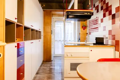 a kitchen with white cabinets and a table at La terrazza di Maria Pia in Rome