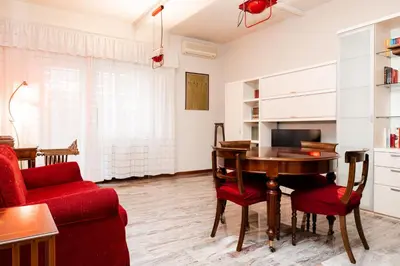 a living room with a table and a red couch at La terrazza di Maria Pia in Rome