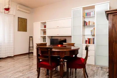 a room with a table and a book shelf at La terrazza di Maria Pia in Rome