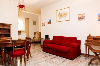 a living room with a red couch and a table at La terrazza di Maria Pia in Rome