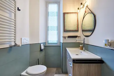 a bathroom with a toilet and a sink and a mirror at Art Gallery House, San Giovanni, Roma Centro - Wifi AC Smart TV in Rome