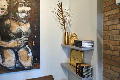 a painting of a man on a wall next to a shelf at Art Gallery House, San Giovanni, Roma Centro - Wifi AC Smart TV in Rome