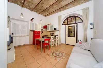 a living room with a white couch and a kitchen at Locazione turistica Via Caltanissetta in Rome