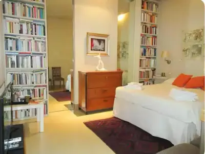 a bedroom with a bed and several book shelves at Carrozze Suite in Rome