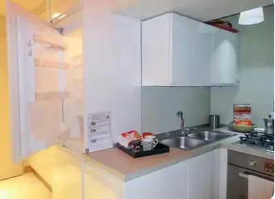 a white kitchen with a sink and a counter top at Carrozze Suite in Rome