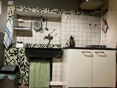 a small kitchen with a sink and a tiled wall at CasaPigneto34 in Rome