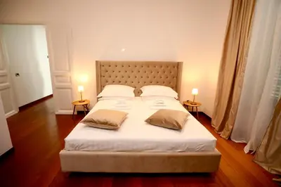 a bedroom with a large white bed with two lamps at Prestige Crescenzio in Rome