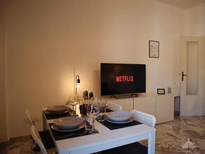 a dining room with a table with a tv on the wall at Gregory Retreat in Rome