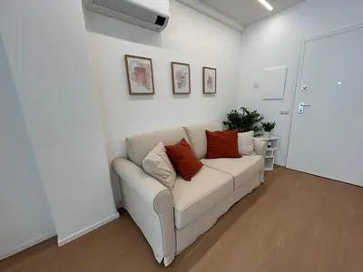 a living room with a white couch with orange pillows at Momenti di serenità a Roma in Rome