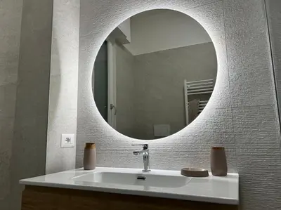 a bathroom with a sink with a round mirror at Momenti di serenità a Roma in Rome