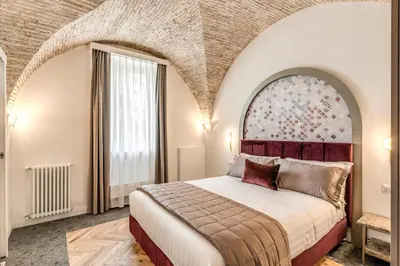 a bedroom with a king sized bed with an arched ceiling at Palazzo Ottavia - La Maison D'art Collection in Rome