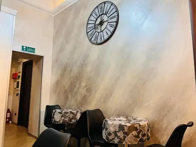a clock on the wall of a waiting room with chairs at Funny place in Rome