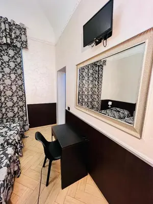 a room with a bed and a mirror and a chair at Funny place in Rome
