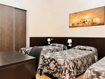 a hotel room with two beds and a table at Funny place in Rome