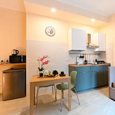 a kitchen with a table and a clock on the wall at Domus Fama in Rome