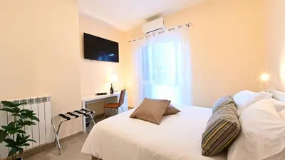 a bedroom with a white bed with a window and a desk at Domus Fama in Rome