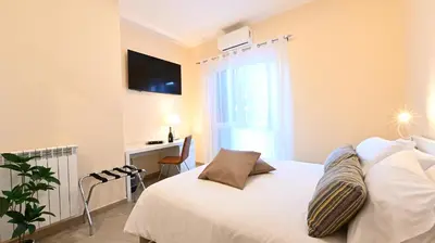 a bedroom with a white bed with a window and a desk at Domus Fama in Rome