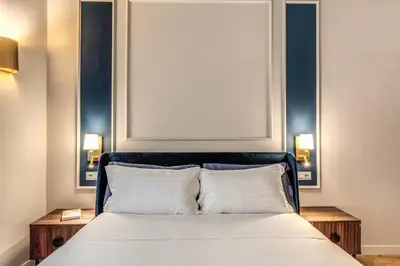 a bedroom with a bed with two nightstands and a framed picture at Appartamento del Fico in Rome