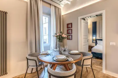 a dining room with a table and chairs and a bed at Appartamento del Fico in Rome
