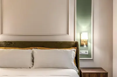 a bedroom with a bed with white pillows and a mirror at Appartamento del Fico in Rome