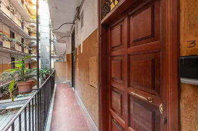 an empty hallway with a wooden door and a balcony at V HOME San Lorenzo in Rome