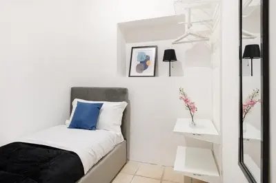 a small bedroom with a bed and a mirror at V HOME San Lorenzo in Rome