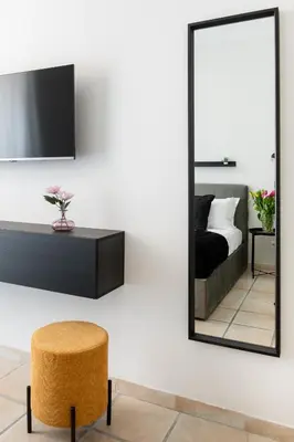 a bedroom with a mirror and a stool at V HOME San Lorenzo in Rome