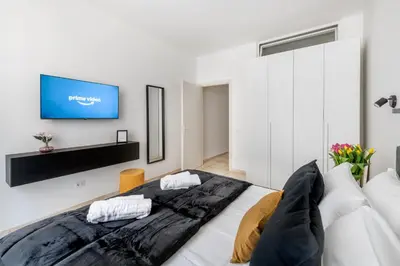 a bedroom with a large bed with a tv on the wall at V HOME San Lorenzo in Rome